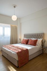 雅典La Residence Athens的一间卧室配有一张带红色枕头的大床