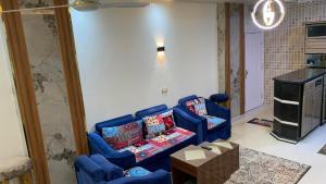 赫尔格达Apartment in Center of Hurghada的客厅配有2把蓝色椅子和桌子