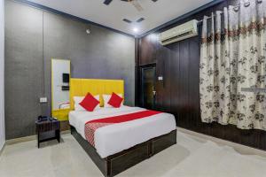 勒克瑙OYO Flagship Ideal Inn的一间卧室配有一张带红色枕头的大床