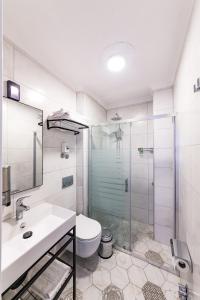 达特恰Özgüm Suite Otel的浴室配有卫生间、盥洗盆和淋浴。