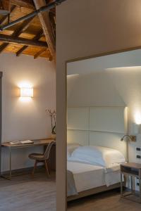 佩鲁贾Le Cappuccinelle Suites&SPA的一间卧室配有一张床、一张桌子和一把椅子