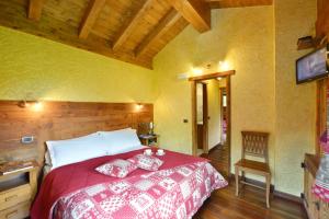 尚波吕克乐佩蒂特阿博丽酒店的一间卧室配有一张大床和红色的被子