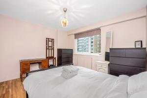 伦敦Queens Park Vibrant 1BR Flat with Balcony的卧室设有一张白色大床和一扇窗户。