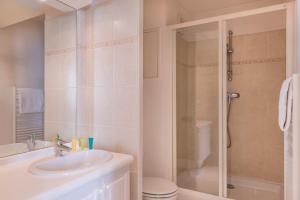 勒普莱西罗班松格朗德公寓大酒店的白色的浴室设有水槽和淋浴。