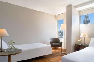 蒙得维的亚蒙得维的亚哥伦比亚NH酒店的酒店客房,配有两张床和椅子