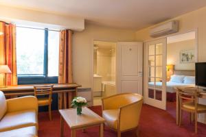 勒普莱西罗班松格朗德公寓大酒店的酒店客房设有床和客厅。