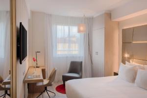 罗马罗马中心NH酒店的酒店客房配有一张床、一张桌子和一把椅子。
