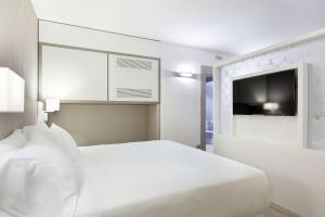阿萨哥NH米兰会议中心酒店的白色卧室配有床和平面电视