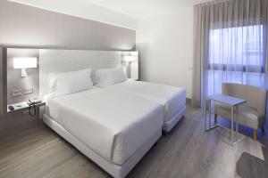阿萨哥NH米兰会议中心酒店的卧室设有一张白色大床和一扇窗户。