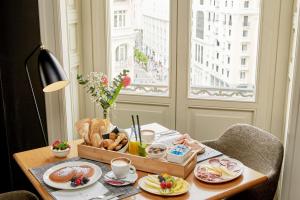 马德里马德里格兰大街乔利酒店的一张桌子,上面放着一个食物盘和一个窗口