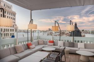 马德里马德里格兰大街乔利酒店的享有美景的屋顶天井配有沙发和桌子。