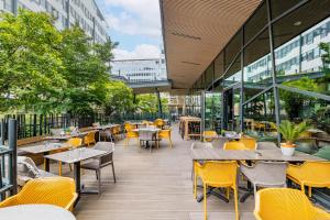 里昂普瑞米尔里昂中央车站经典酒店的餐厅设有黄色的椅子和桌子以及窗户。