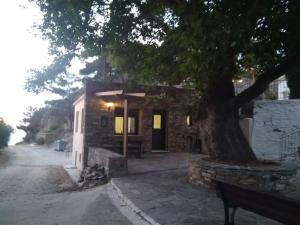 KouniádhoiHouse in Vrakades Village的一座有树和长凳的建筑