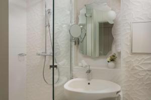 巴黎NH Paris Gare de l'Est的浴室配有盥洗盆和带镜子的淋浴