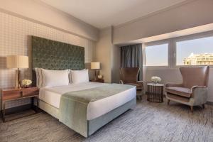 里斯本Tivoli Oriente Lisboa Hotel的配有一张床和一把椅子的酒店客房
