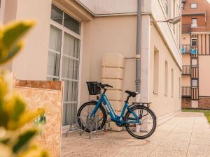 滨海维莱多维尔维莱海滨宜必思尚品酒店 的停在大楼旁边的一辆蓝色自行车