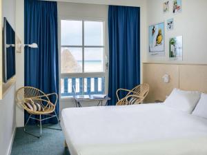 滨海维莱多维尔维莱海滨宜必思尚品酒店 的酒店客房带床、椅子和窗户
