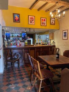 梅尔顿莫布雷The Kings Arms (Scalford)的餐厅内的酒吧配有木桌和椅子