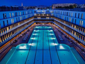 巴黎Molitor Hôtel & Spa Paris - MGallery Collection的一座大型建筑,晚上设有游泳池