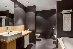 根特NH根特贝尔福特酒店的一间带水槽、浴缸和卫生间的浴室