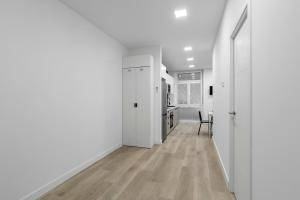 马德里GuestReady - Ideal Stay in Vibrant Ciudad Lineal的白色走廊,设有厨房和用餐室