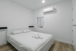 马德里GuestReady - Ideal Stay in Vibrant Ciudad Lineal的白色卧室配有白色床单