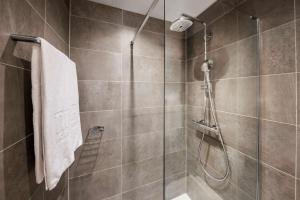 卢森堡卢森堡NH酒店的带淋浴的浴室和玻璃门