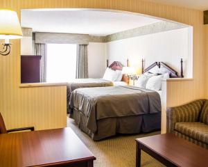 麦卡莱斯特麦卡莱斯特康福特套房酒店的酒店客房,配有两张床和椅子