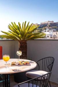 雅典Athens Ivy Suites的一张桌子,上面有盘子和一棵棕榈树