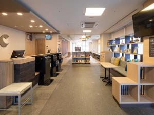 吴市吴市凯富特酒店的一间在商店里设有桌子和架子的等候室