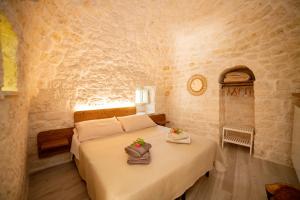 洛科罗通多Trulli Balè的卧室配有一张石墙床