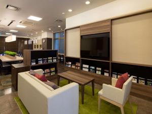 山形市山形舒适酒店的客厅配有两把椅子、一张桌子和一台电视