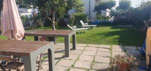 泰尔莫利Simpatico appartamento autonomo sul mare的庭院设有两把木桌和椅子