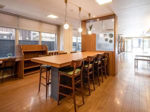 山口新山口康福酒店的用餐室配有大型木桌和椅子