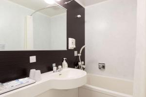 八户市八户康福特茵酒店的浴室设有白色水槽和镜子