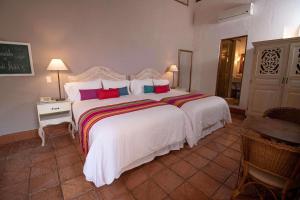 卡塔赫纳Hotel Bantu by Faranda Boutique, a member of Radisson Individuals的卧室配有一张带彩色枕头的大型白色床。