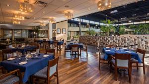 Ville Saint LaurentRadisson Hotel Montreal Airport的一间在房间内配有蓝色桌椅的餐厅