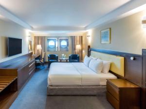 迪拜Queen Elizabeth 2 Hotel的酒店客房,配有床和电视