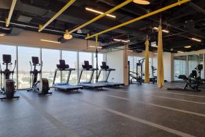 迪拜First Class 1BR Apartment in Dubai Hills - next to Dubai Hills Mall的健身房设有数排跑步机和健身自行车