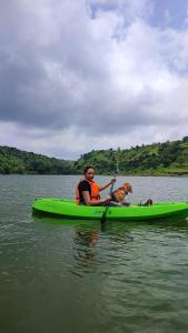 Daulatābād西拉尼亚度假酒店的水面上划皮艇的男人和狗