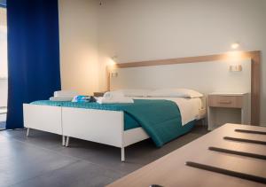 圣玛丽亚纳瓦雷Resort Beach Cala Goloritzè的一间卧室配有一张带绿毯的床