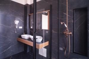 奥里斯塔诺New Elegance Suites Guesthouse的一间带两个盥洗盆和淋浴的浴室