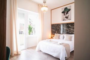 奥里斯塔诺New Elegance Suites Guesthouse的白色的卧室设有床和大窗户