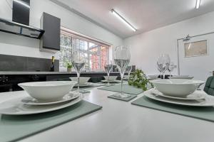 基德明斯特Guest Homes - Chester House Retreat的厨房配有带盘子和酒杯的桌子