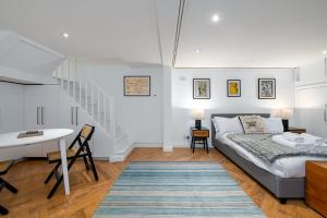 伦敦GuestReady - Charming studio in Hackney的一间卧室配有一张床、一张书桌和一个楼梯