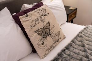 伦敦GuestReady - Charming studio in Hackney的床上的枕头上有一个蝴蝶