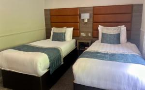 科尔雷恩Bushtown Hotel & Spa的配有衬衫的酒店客房内的两张床