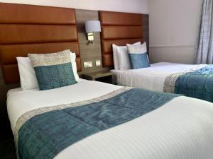 科尔雷恩Bushtown Hotel & Spa的酒店客房,配有两张蓝色和白色的床