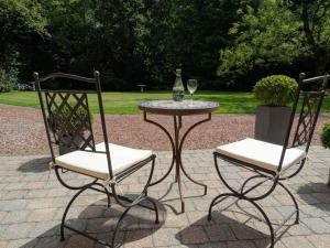 RuiseledeB&B Castel 't Haantje的两把椅子和一张桌子及葡萄酒杯