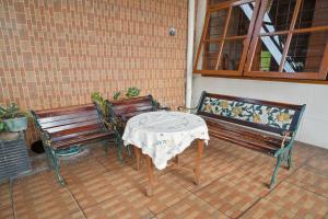雅加达Wisma Rumka的两张长椅和一张桌子及一张桌布